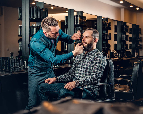 Barbiere taglia la barba di un uomo
 - Foto, immagini
