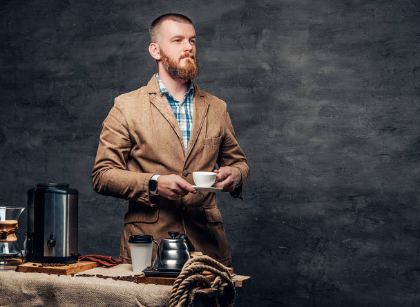 Bearded male near a table with coffee machine - Foto, imagen