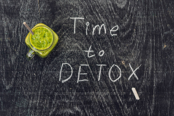 TIME TO DETOX chalk inscription on the wooden table and Green smoothies made of spinach. Healthy eating and sports concept - Foto, Bild