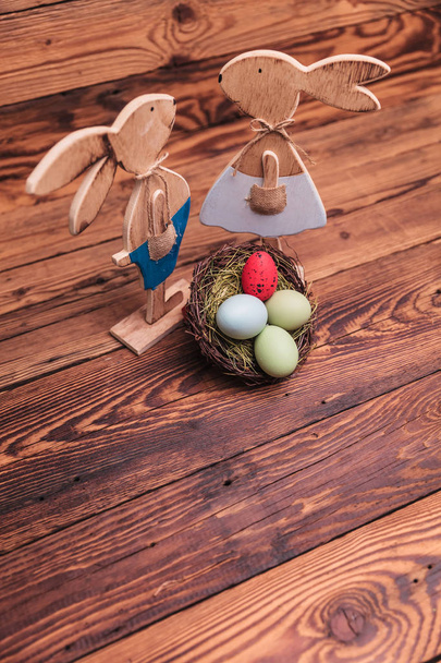 picture from above of wooden easter bunnies near egg basket  - Photo, Image