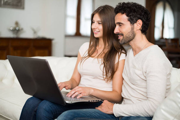 ευτυχισμένο ζευγάρι που χρησιμοποιεί φορητό υπολογιστή  - Φωτογραφία, εικόνα
