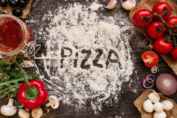 Cooking Pizza. Pizza ingerdients on the wooden table, top view - 写真・画像