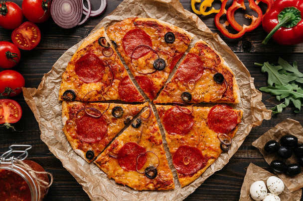 Fresh delisious pizza with pizza ingredients on the wooden table, top view - Fotoğraf, Görsel