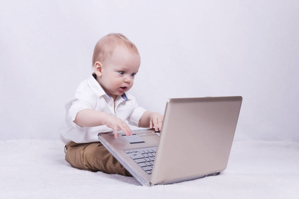 Concentrated baby boy playing or programming on laptop. Concept of new it generation - Fotoğraf, Görsel