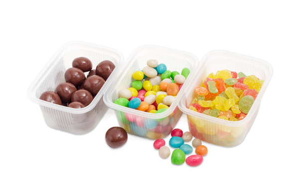 Três variedade de doces diferentes em pequenos recipientes de plástico
  - Foto, Imagem