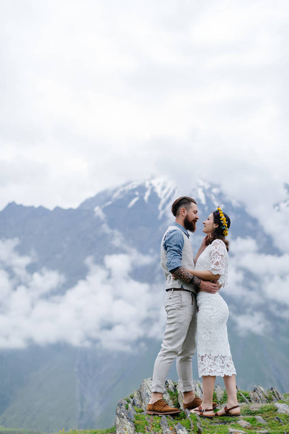 pareja joven en el amor, abrazos, un hombre en un traje y una chica en blanco con flores
 - Foto, Imagen