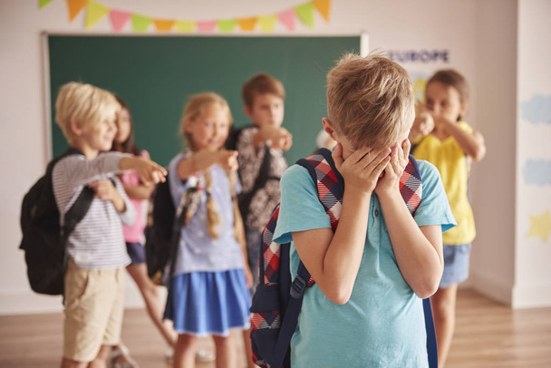 boy standing sad in front of classmates - Photo, Image