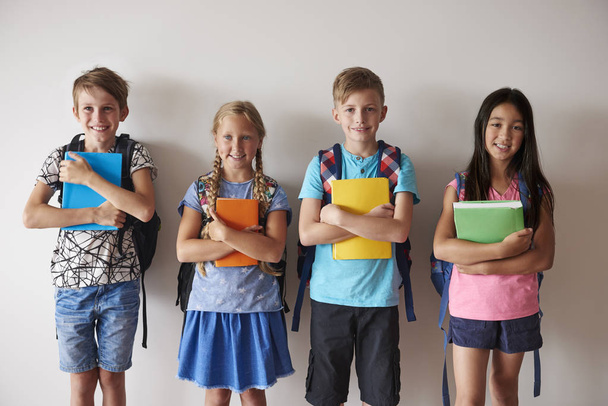 smiley kids with backpacks holding books - Foto, Imagem