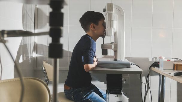 Хлопчик перевіряє зір в офтальмологічній клініці
 - Фото, зображення