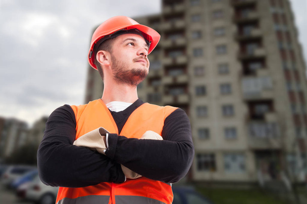 Уверенный молодой строитель позирует со сложенными руками
 - Фото, изображение
