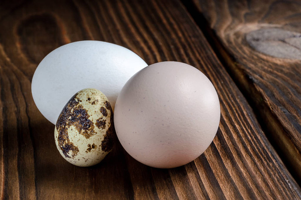 Ovos de galinha e codorniz em um fundo de madeira
 - Foto, Imagem