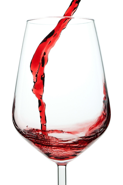 Splash of red wine in a glass. Closeup. - 写真・画像