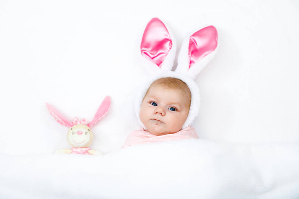Adorable cute newborn baby girl in Easter bunny costume and ears. - Foto, afbeelding