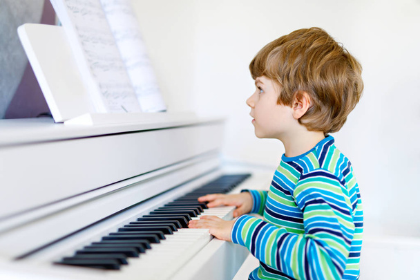 Bellissimo ragazzino che suona il pianoforte in salotto o nella scuola di musica
 - Foto, immagini