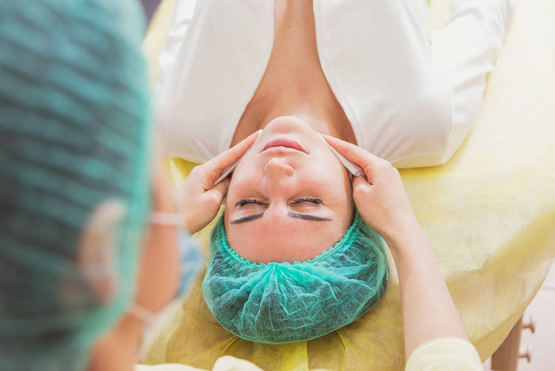 Face massage. Girls doing facial massage in the beauty salon - Fotó, kép