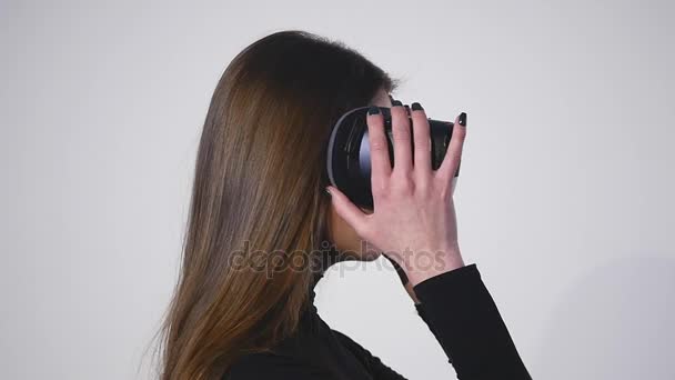 Woman uses a head mounted display. A woman in a virtual reality mask looks around - Filmati, video