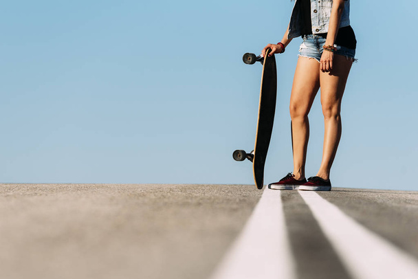 Beautiful skater woman posing with her longboard. - Zdjęcie, obraz