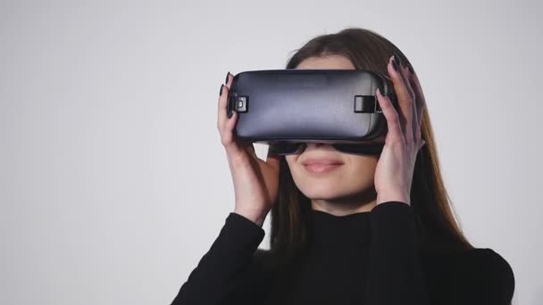 Woman uses a head mounted display. A woman in a virtual reality mask looks around - Materiał filmowy, wideo