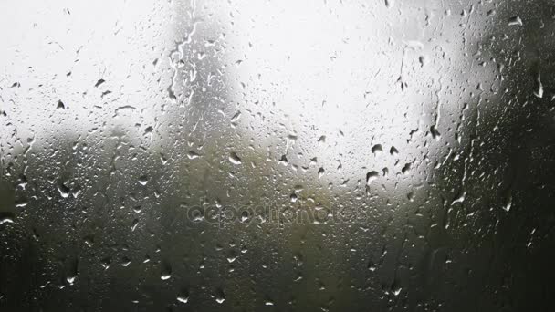 Close-up van waterdruppels op glas. Regen druppels op vensterglas met vervaging achtergrond. Wazig boom en hemel. Regenachtige dagen, regen rennen venster, bokeh - Video
