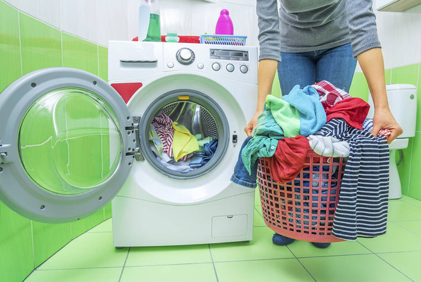 Woman holding a basket of dirty laundry. - Фото, изображение