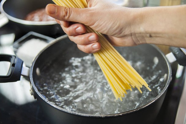 Kaynar suyla birlikte tencerede spagetti pişirmek. - Fotoğraf, Görsel