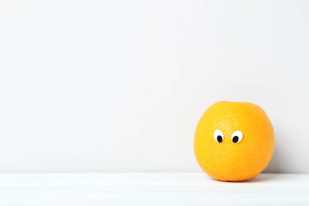 Ripe orange with googly eyes - Φωτογραφία, εικόνα