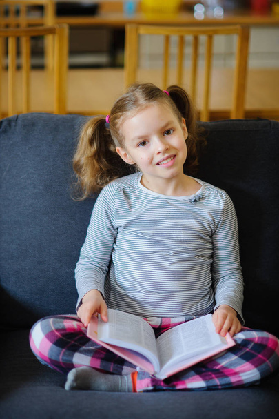 Roztomilá dívka mladšího školního věku čte knihu. - Fotografie, Obrázek
