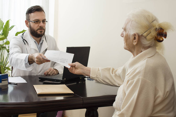Ένας γιατρός δείχνει ένα δάχτυλο εγγράφως, το ιατρικό ιστορικό του ασθενούς. - Φωτογραφία, εικόνα