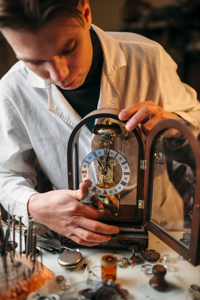 годинникмейкер зі старим годинником
 - Фото, зображення