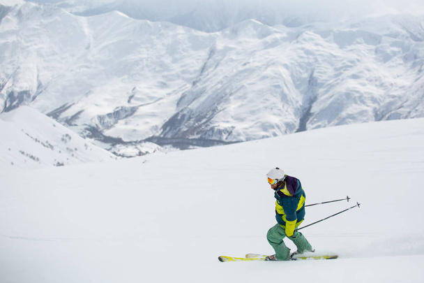 lyžař lyžování na čerstvém sněhu na sjezdovce na slunný zimní den v lyžařském středisku v Gruzii - Fotografie, Obrázek