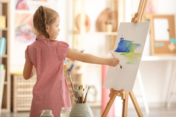 Cute little artist painting picture in studio - Фото, изображение