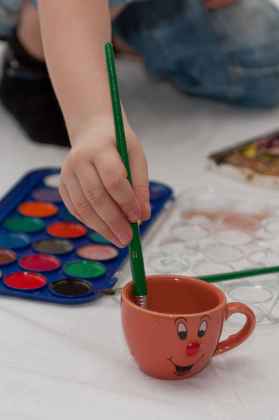 The child draws a brush and water color paints - Photo, Image