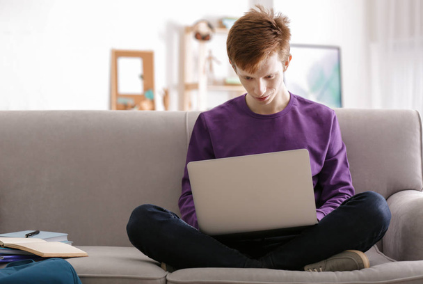 Adolescent travaillant avec un ordinateur portable à la maison
 - Photo, image