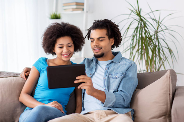 smiling happy couple with tablet pc at home - Photo, image
