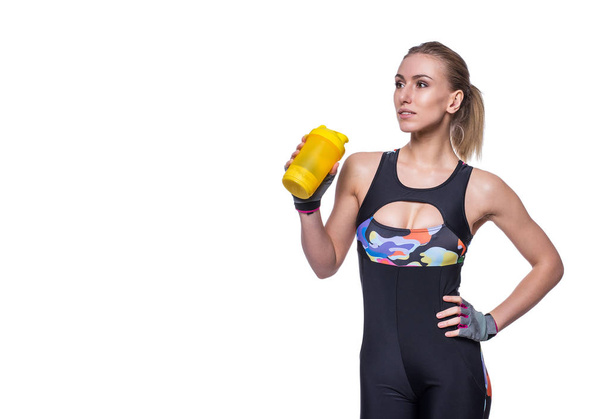 Attractive athletic woman relaxing after workout with shaker isolated over white background. Healthy girl drinks whey protein. Copyspace for text. - Φωτογραφία, εικόνα
