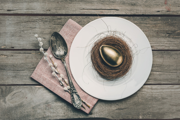 Golden Easter egg on plate  - Фото, зображення