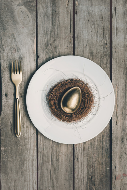 Huevo de Pascua dorado en plato
  - Foto, imagen