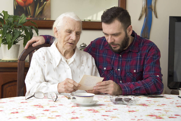 Grandson showing grandmother's photo album. Family meeting.  - Fotoğraf, Görsel