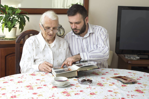 Babička s vnukem připomínají staré časy pozorování fotoalbum.  - Fotografie, Obrázek