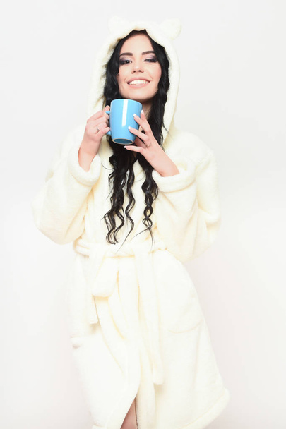 smiling sexy girl posing in beige velour bathrobe with cup - Fotoğraf, Görsel