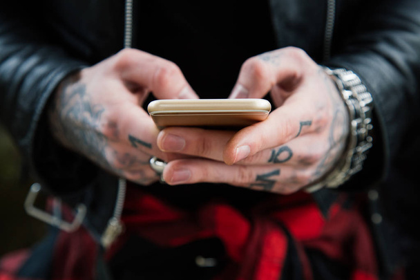 Tattooed man hands with smartphone - Foto, afbeelding