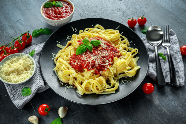 Pâtes chaudes maison avec sauce marinara, basilic, ail, tomates, parmesan dans l'assiette
. - Photo, image