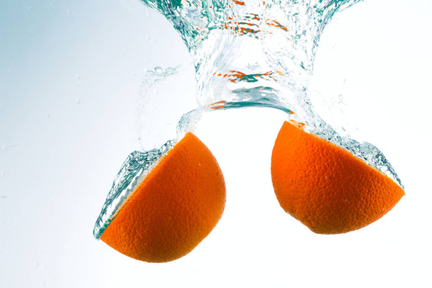 Orange in streams of water on a white background - Фото, зображення