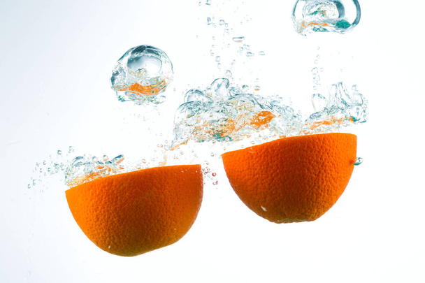 Orange in streams of water on a white background - Foto, Imagen