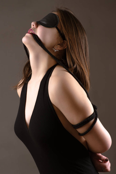 attractive brunette girl with blindfold on eyes - Photo, Image