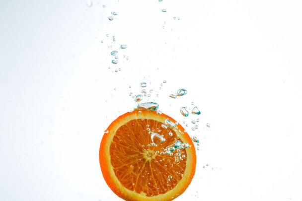 Orange in streams of water on a white background - Photo, Image