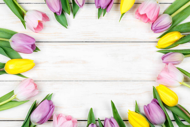 Bunch of pink and yellow tulips on a white wooden background - Foto, Imagem