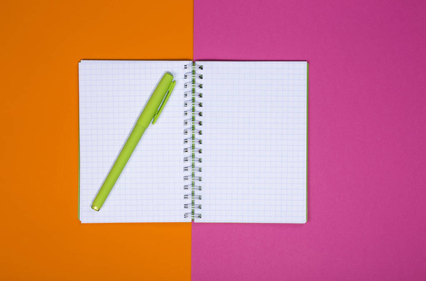 Open notebook en pen op een gekleurde achtergrond  - Foto, afbeelding