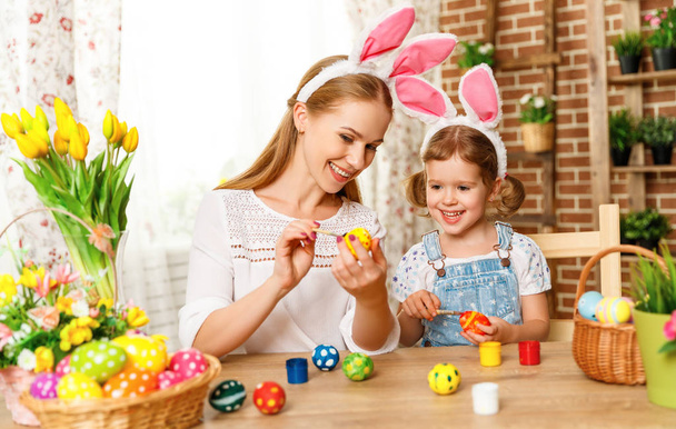 Joyeux Pâques ! famille mère et enfant fille peinture oeufs pour ho
 - Photo, image