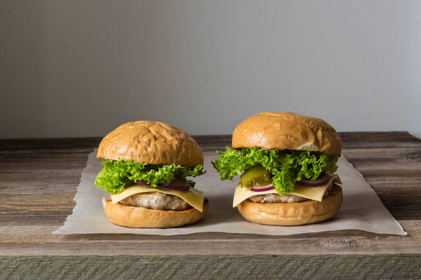 home made tasty burgers on wooden table. - Φωτογραφία, εικόνα